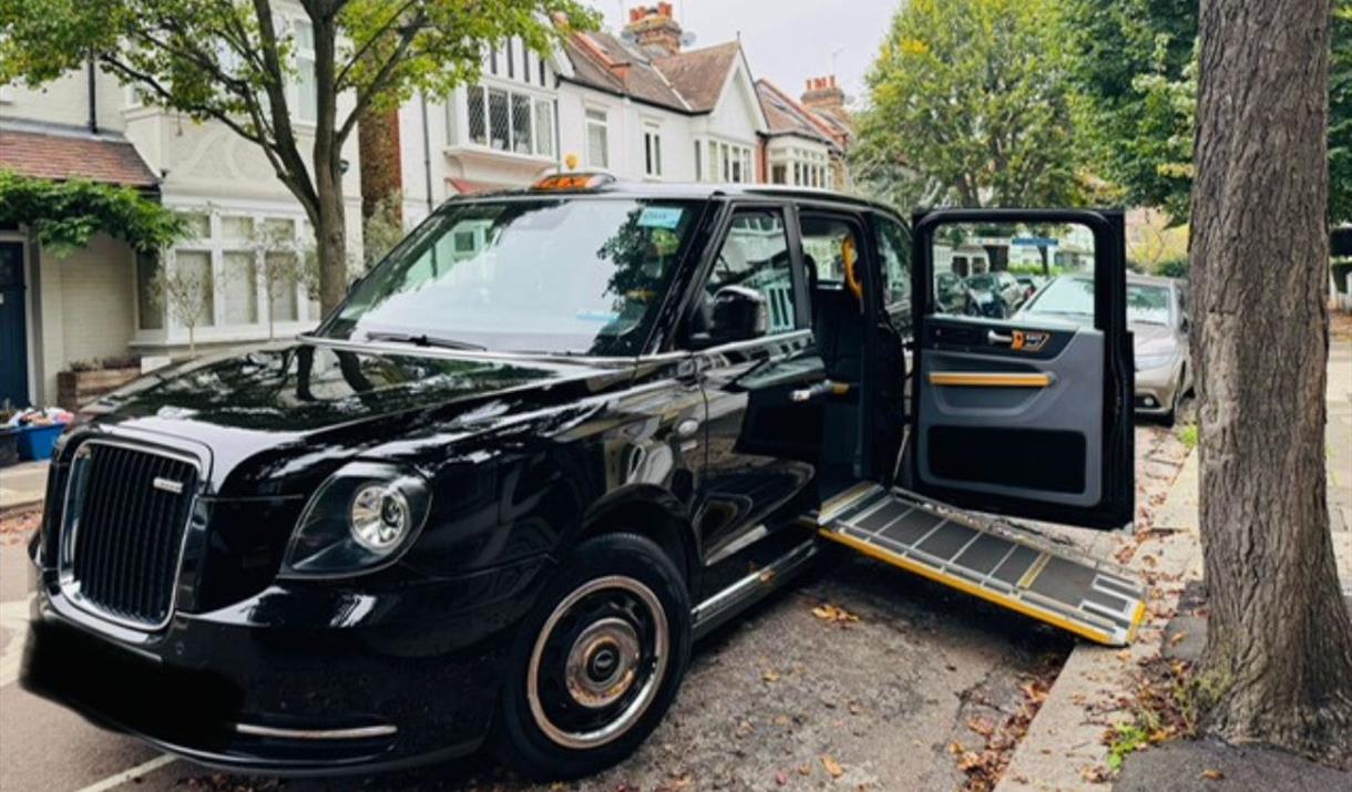 Taxi4Hire's black cab parked on the side of the road with the ramp out