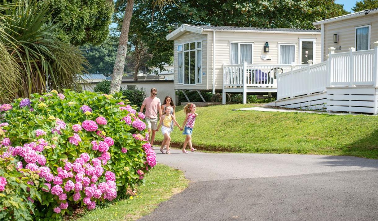 Family walking past the lodges at John Fowler Holiday Parks