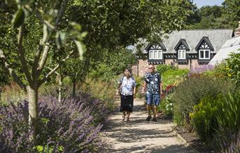 A couple walking through a garden area at National Trust Quarry Bank
