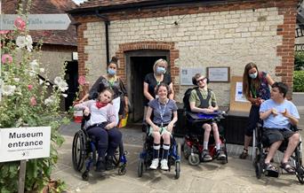 A group of people in wheelchairs at the entrance to Gilbert White's House