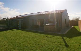 Outside Mountain Lodge showing the lawn and the hot tub