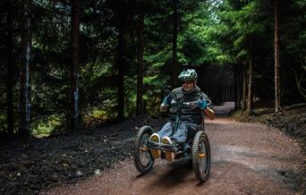 a man riding an adapted bike through the forest