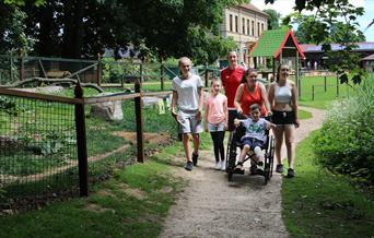 Family exploring Thrigby Hall Wildlife Gardens, with one child in a wheelchair