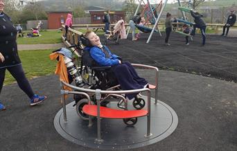 A child in a wheelchair in the wheelchair friendly play area  at Noah's Ark Zoo Farm