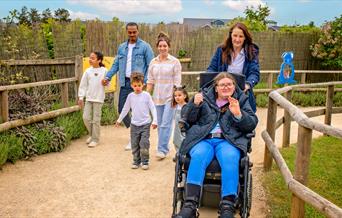 A group of people following the path at Fairytale Farm, with one girl in a wheelchair in front