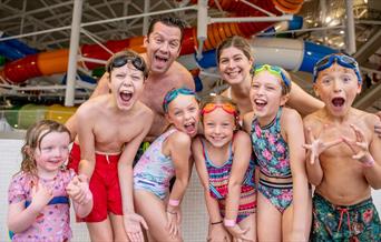 Aa group of children with two adults in swim wear at the Wave