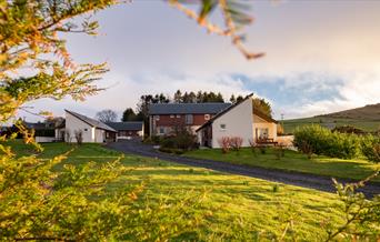 The outside of Elderburn Lodges. Image taken through trees