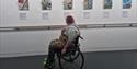 a person in a wheelchair looking at photos at the Level Centre