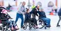 The ice rink at Clarks Village featuring several visitors using wheelchairs on the ice