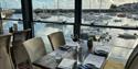 Indoor seating with a view over the harbour from The Boat House and The Anchor Club