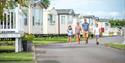 Family walking through John Fowler Holiday Parks passing caravans