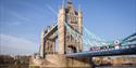 A red bus driving over Tower Bridge