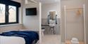 Bedroom with ensuite accessible bathroom, with handrails