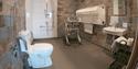 Accessible bathroom at Mountain Lodge with shower chair and hand rails