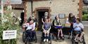 A group of people in wheelchairs at the entrance to Gilbert White's House