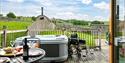 The decking at Hoe Grange Holidays with a wheelchair next to the hot tub