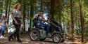 Group of women enjoying the trails at Haldon Forest Park with one person riding in an all terrain tramper