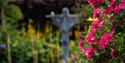 Flowers in the foreground and a sculpture in the background at Helmsley Walled Gardens