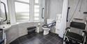 accessible bathroom with shower chair and hand rails at Marsham Court Hotel