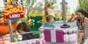 People riding a ride at Crealy Theme Park with a Sooty land logo in the top left corner
