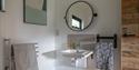 Oak Tree Cabin's accessible bathroom, with lowered sink and adjustable mirror, suitable for wheelchair users.