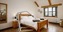 Coach House Cornwall Bedroom with a portable hoist over a wooden bed