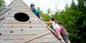Children climbing a wooden triangle at Bedgebury National Pinetum and Forest