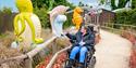 Person in a wheelchair looking at the displays at Fairytale Farm