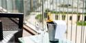 Bottle of champagne and glasses on a table outside The Royal Yacht Hotel