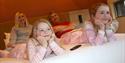 a family led on a double bed watching tv together at HEX Hotel at Yorkshire Wildlife Park