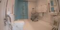Wet room with shower chair at Coastal Cottage