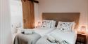 Twin beds at Sandhole Cottages showing the ensuite bathroom