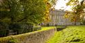 The house in the background with trees in front of it Petworth House & Park