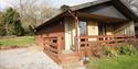 outside of woodcombe cottages showing the parking area and the steps and ramp up to the door