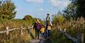A family walking along one of the pathways at WWT Arundel Wetland Centre