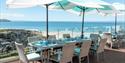 Table set up for dinner on the decking overlooking the beach at Watersmeet Hotel