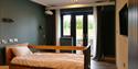 Accessible bedroom with single bed and floor to ceiling windows