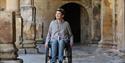 Person in wheelchair exploring The Roman Baths