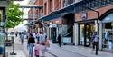 People with shopping bags walk through Gunwharf Quays Shopping Centre