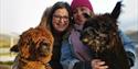 A couple with two alpacas at Alpacaly Ever After