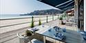 Tables set up for diners on the terrace next to the beach at Oyster Box