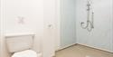 Hall Farm Cottage Bathroom showing a toilet and a level shower area with a handrail
