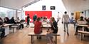 The cafe area at Sadler’s Wells with people sitting at tables and working on laptops