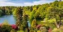 Gardens and lake at National Trust Stourhead, with lots of trees in the foreground and background