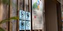 Four accessibility signs on display before the Lorikeet enclosure at Longleat