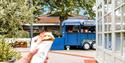 A burrito held in front of the food truck it came from at Clarks Village