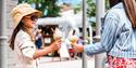Two young people holding Mr Whippy ice creams at Clarks Village