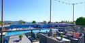 Dining and seating area overlooking outdoor swimming pool and sea views at Beverley Holidays