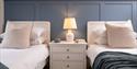 Two single beds with some blue panelling behind