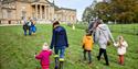 Families walking on the grass towards Stourhead House. Credit National Trust Images Arnhel de Serra